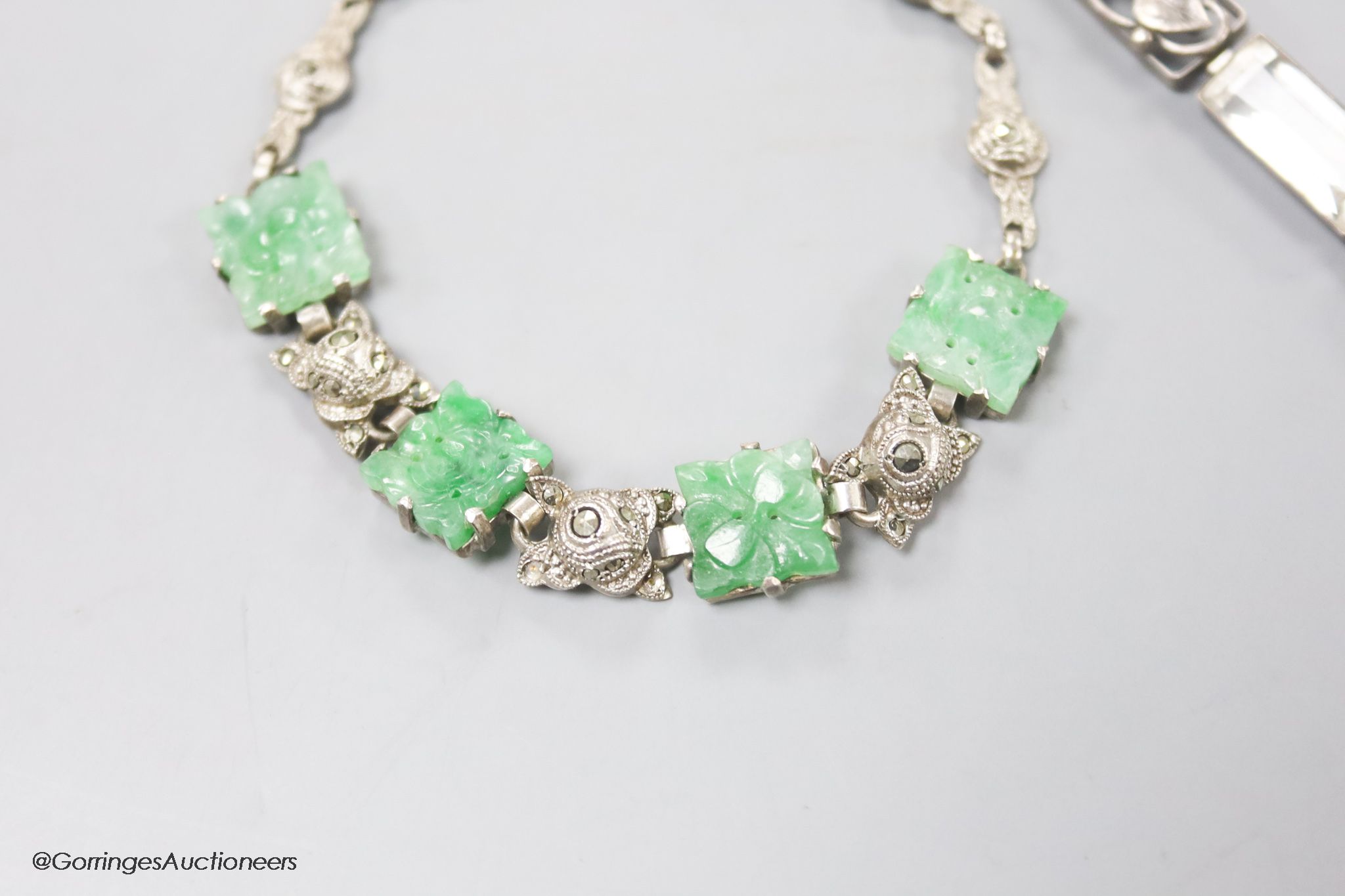 A white metal and carved jade set bracelet and one other bracelet.